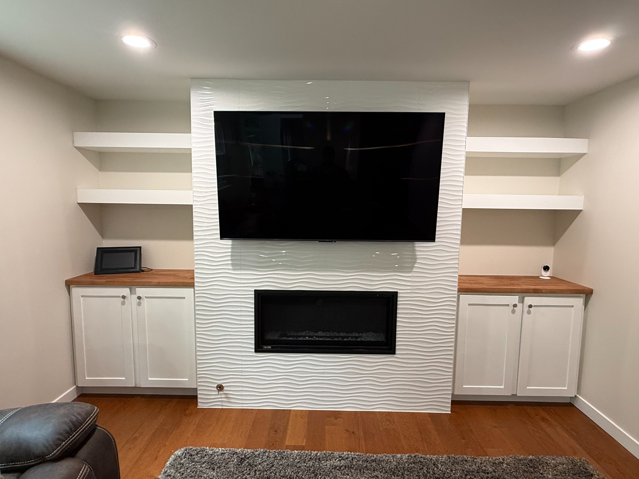 Final product — custom built-in cabinets, stained butcher-block countertops, and birch-plywood floating shelves