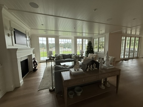 Living room with fireplace, paneled ceiling, and large windows